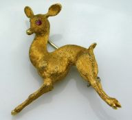 An 18ct gold deer brooch set with ruby eyes, 34mm