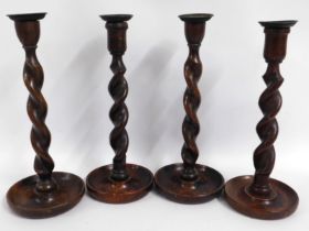 A set of four barley twist oak candle holders, 12.