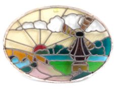 An oval leaded glass window with sunrise & windmil