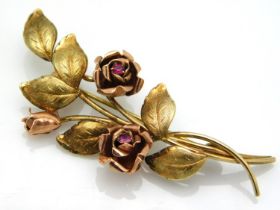 A two colour 9ct gold brooch with roses set with r