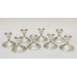 Set of eight sterling silver low candlesticks