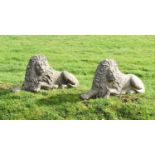 Pair of composite stone garden lions in recumbent posture