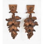 Pair of carved wooden wall appliqués with fruit decoration, 55cm high