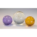 Three glass paperweights with bubble inclusions