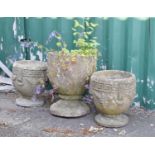 Three composite stone circular garden urns or pots