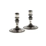 Pair of unmarked white-metal miniature candlesticks