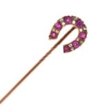 A diamond and ruby horseshoe stick pin