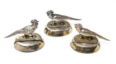 Set of three George V silver menu holders in the form of a Chinese pheasant