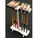 A set of six croquet mallets in rack (balls missing).