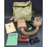 Military interest: Vintage World War 2 era gas mask together with two military books and a miniature