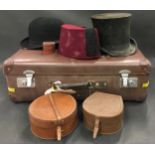 Vintage globe trotter suitcase containing vintage gentleman’s hats and two smaller leather cases.