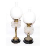 Two antique oil lamps in excellent condition with clear glass reservoirs. Largest is 66cms tall