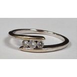 A three stone diamond modernist 18ct white gold ring, Size V, 3.9g