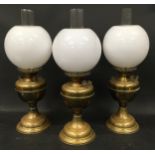 Three vintage Duplex oil lamps each with glass chimney and opaline glass globe shade.