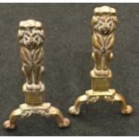 Pair of vintage cast iron fire dogs depicting brass lions each 45cm tall.