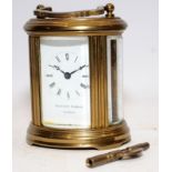 Quality Matthew Norman miniature oval carriage clock with key. Seen working. All bevelled glass