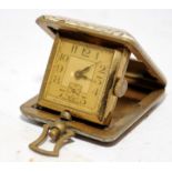 Miniature 1930's manual wind folding travel clock, 4cms across not including winder. Winds and