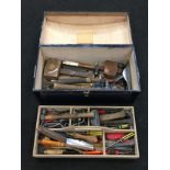 A wooden box containing a large collection of various vintage hand tools.