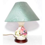 Small Moorcroft table lamp c/w shade in the Magnolia pattern. 34cms tall including shade