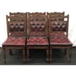 A set of six oak dining chairs with button back leather upholstery.