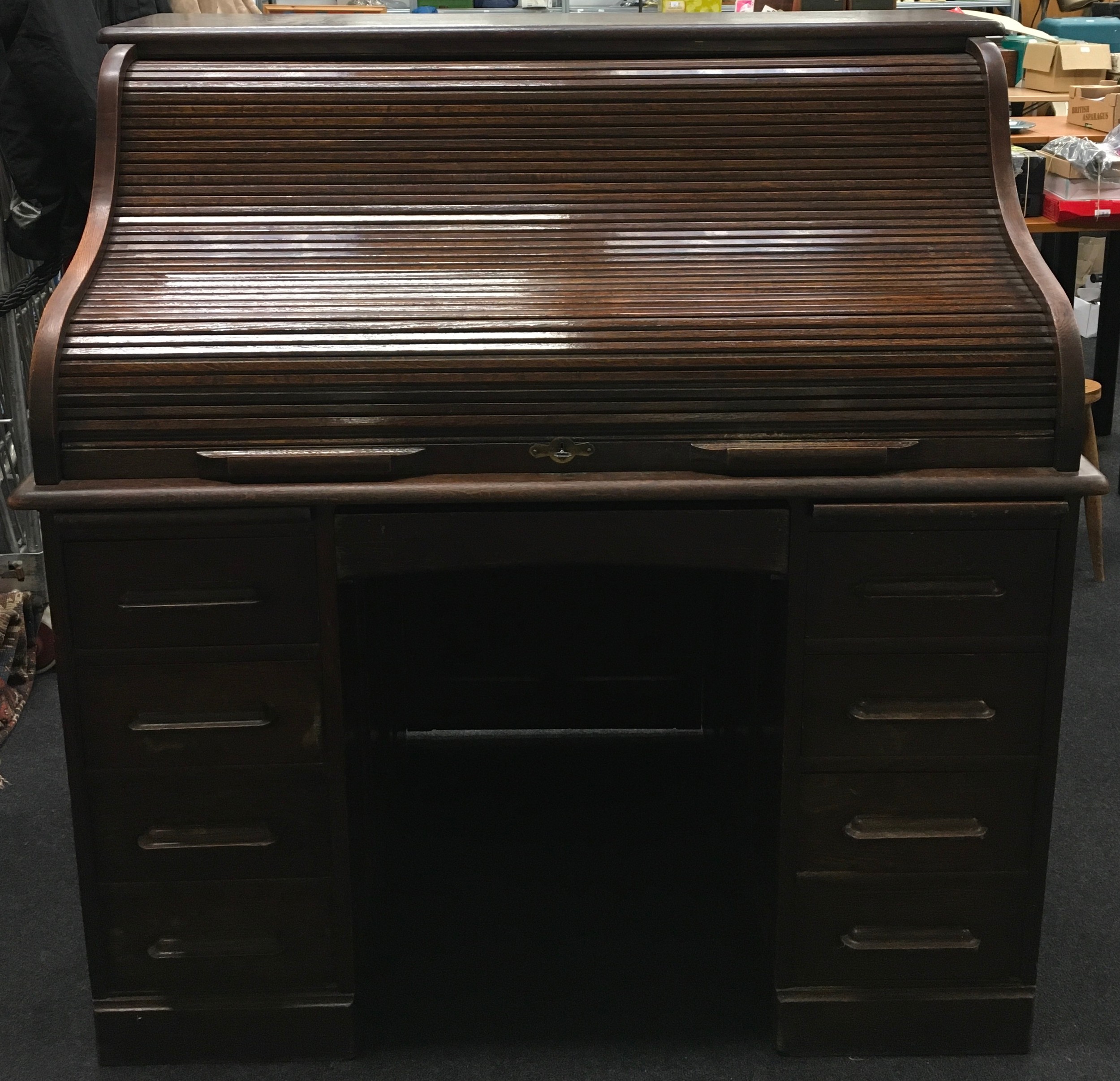 Antique oak roll top pedestal desk fitted with seven drawers 125x122x76cm.