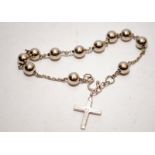 A silver ball chain bracelet with crucifix pendant.