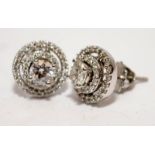 A pair of diamond earrings, solitaire centre stone approx. 0.33pts each surrounded by two rows of
