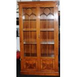 Tall walnut veneer glazed two door display unit with interior lighting. Glazed panels to front and