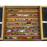 A display cabinet containing a collection of model cars to include Scalextric cars