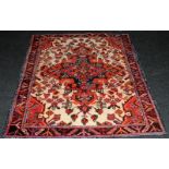 Vintage hearth rug with age related wear. Mostly reds on a cream ground. 150cms x 110cms