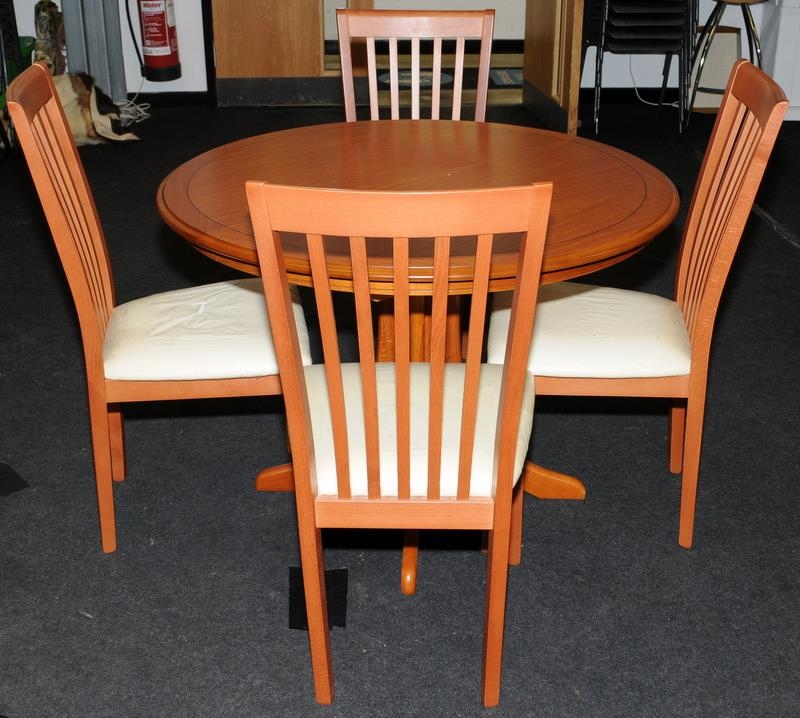 Circular extending table by Morris Furniture Co. c/w with four upholstered dining chairs. 140cms