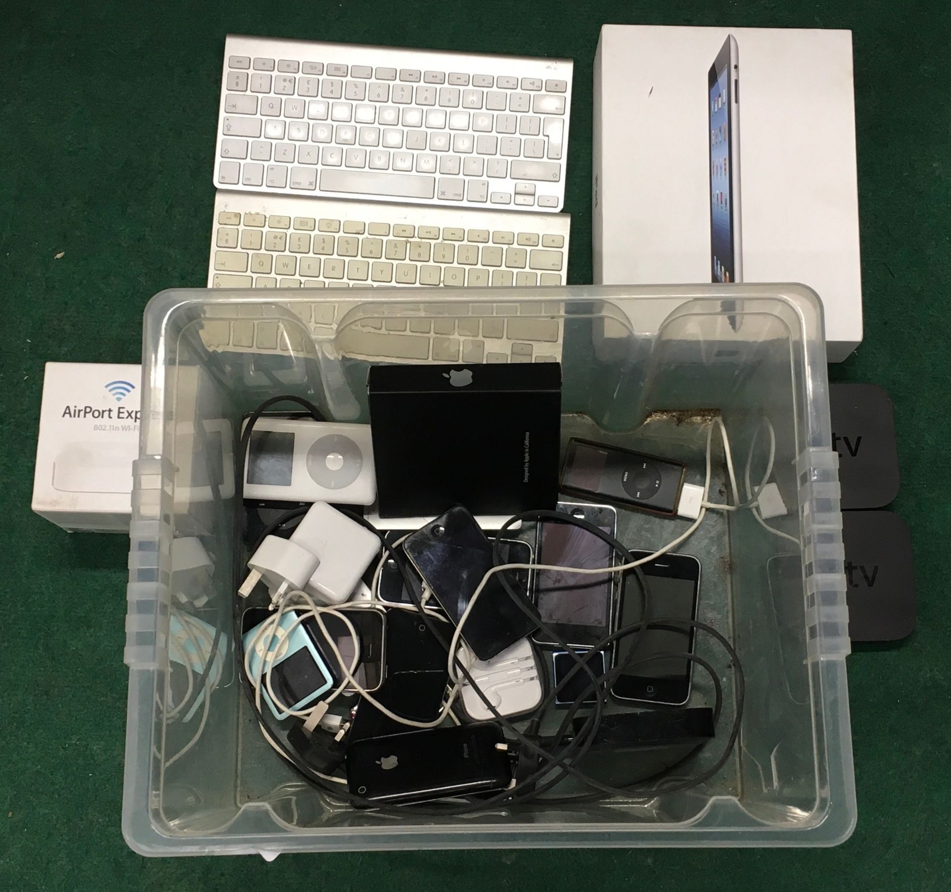 A box of various Apple products including iPad, iPhones and Apple TV boxes.