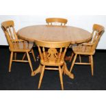 Extending pine kitchen table with four chairs. 137cms across when extended
