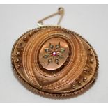 Victorian mourning brooch with ruby and seed pearls central panel. Exhibition back containing a lock