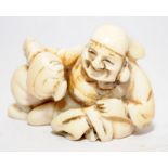 Antique Netsuke depicting a seated old man. Signed to underside