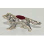 A silver dog pin cushion