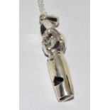 Silver whistle in figural form on silver chain.