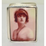 A silver pill box with nude enamel image of a lady.