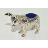 A silver pin cushion in the form of a donkey with sapphire eyes.