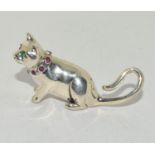 A silver cat figure with ruby set collar.