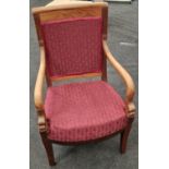 Antique French oak open armchair with decorative carved motifs to arms. Upholstered in a red fabric.