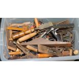 Tub containing a large number of vintage tools including planes and chisels