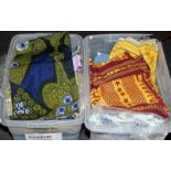 Large quantity of bolts of fabrics in bright African style prints. Two large tubs