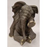 Large resin model of a sitting baby elephant wiping a tear 50cm tall.