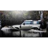 Large contemporary promotional photograph of a Land Rover discovery driving through a puddle