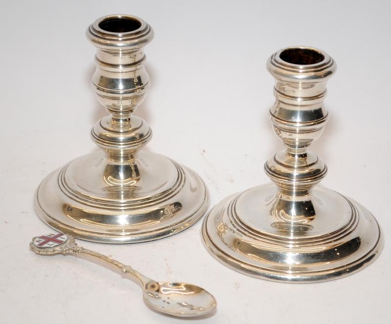 A pair of squat silver candlesticks with weighted bases and worn hallmarks together with a