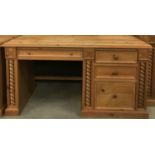 Solid pine desk having 3 side draws and centre draw with turned decoration and carved motifs