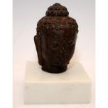 Bronze buddha head mounted on a marble plinth. 13cms tall