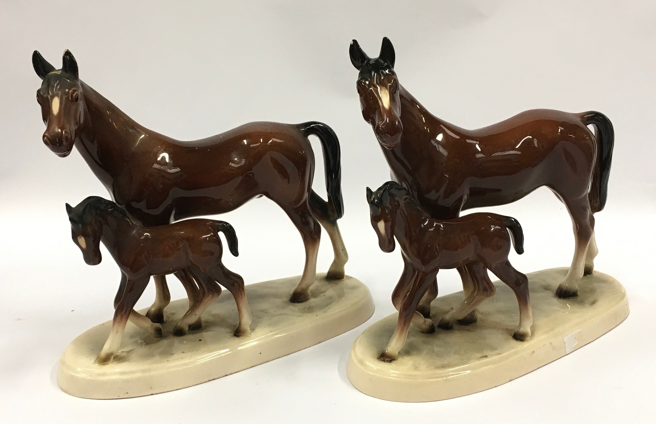 A pair of ceramic horse and foal figurines with marks to bases each measuring 19cm tall.