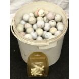A large tub of used golf balls together with a packet of tees.